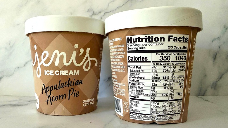 Two pints of Jeni's Appalachian Acorn Pie ice cream, one with nutrition label showing, on marble surface