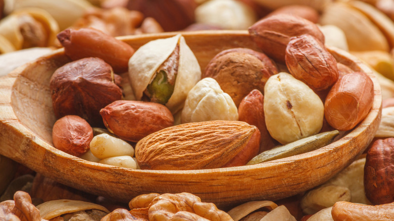 Wooden bowl filled with various nuts.