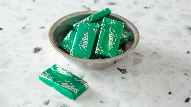 A metal bowl of wrapped Andes mints sits on a counter.