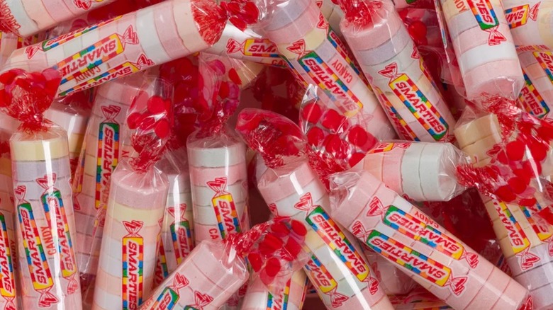A pile of 10-tablet Smarties rolls, available for as low as 2 cents per roll