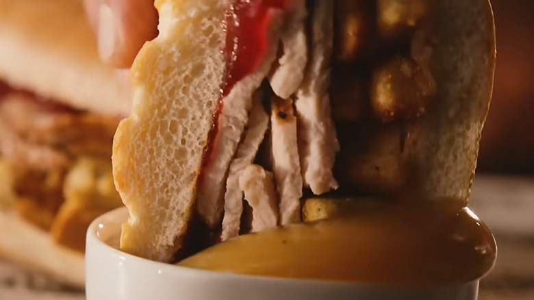 A Firehouse Subs Thanksgiving Turkey Sub is dipped in gravy.