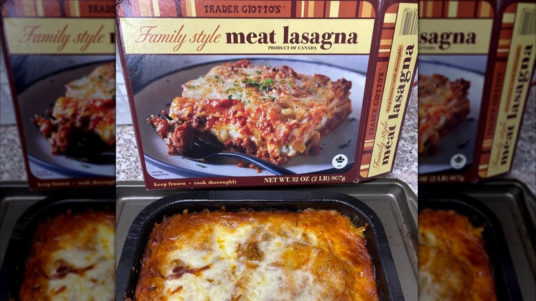 Trader Joe's family style meat lasagna box alongside freshly baked lasagna on baking tray