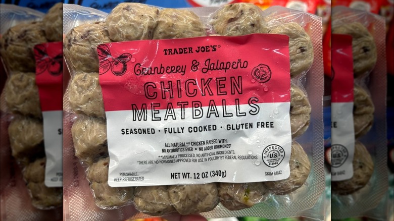 A person holding a package of Trader Joe's Cranberry Jalapeño Chicken Meatballs
