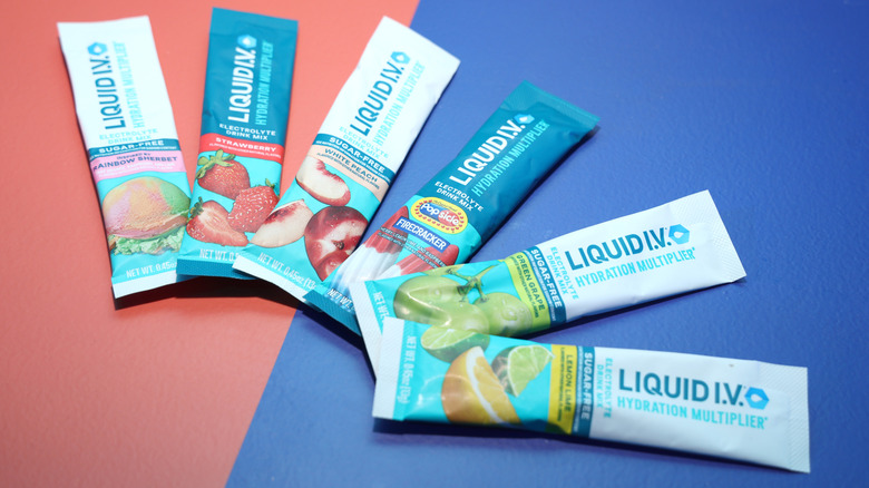 To-go packets of Liquid I.V. in different flavors against pink and blue background
