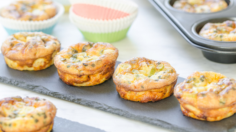 Golden baked egg bites sitting on a stone tray