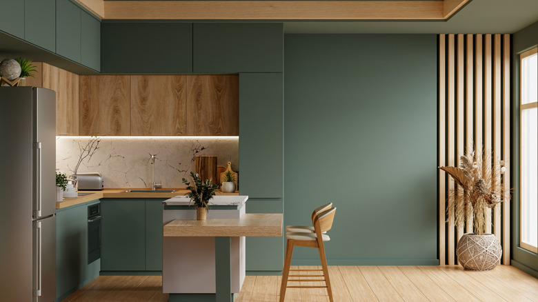 Kitchen with a mixed interior of dark sage and light wood.