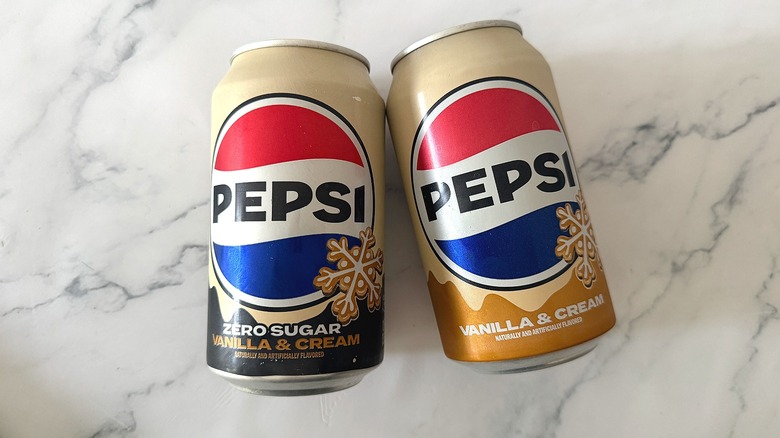 Cans of Pepsi Zero Sugar Vanilla & Cream and Pepsi Vanilla & Cream lying on marble surface