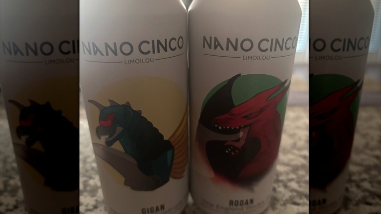 Two cans of Nano Cinco Kaiju beer, one featuring Gigan and one featuring Rodan.
