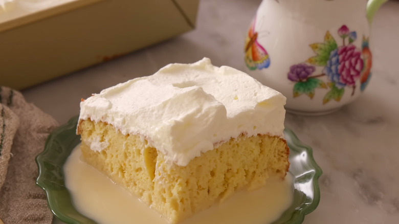 slice of tres leches cake topped with whipped cream
