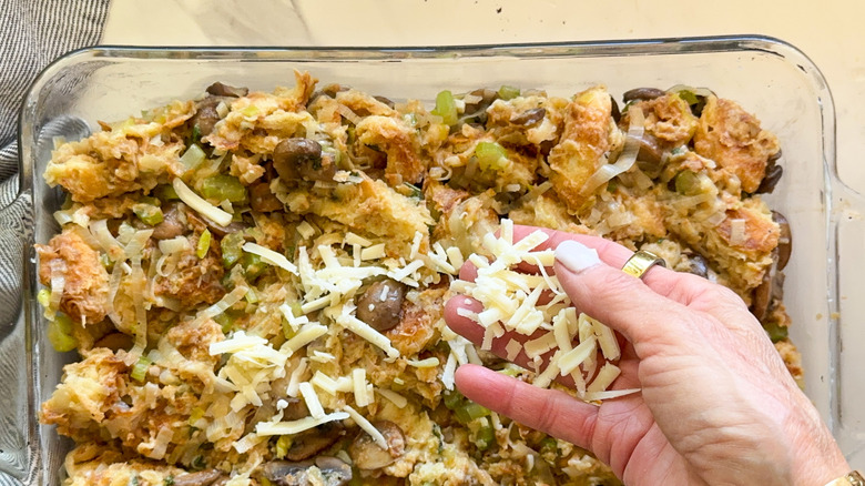 hand adding cheese