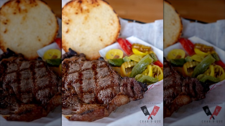 Filet Mignon Sandwich open-faced on white paper with grilled peppers to the side