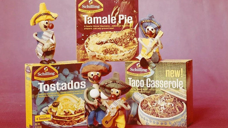 Boxes of Schilling Mexican dinner kits stacked next to Mariachi-themed dolls