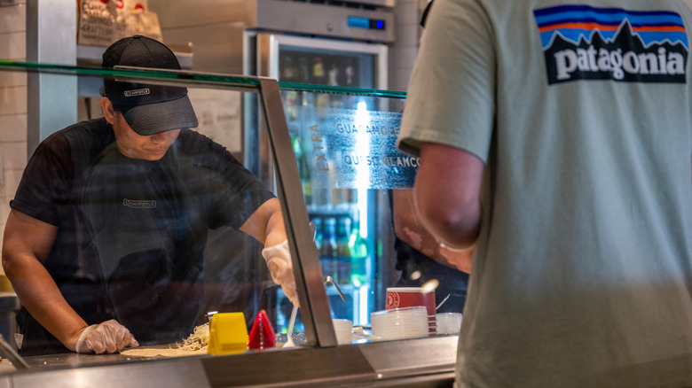 worker making burrito at Chipotle