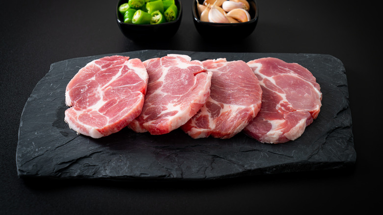 Pork collar steaks on cutting board